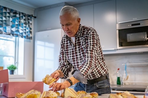 Arbetsledare Kenneth Stenmark serverar kaffe och tårta till arbetsgänget